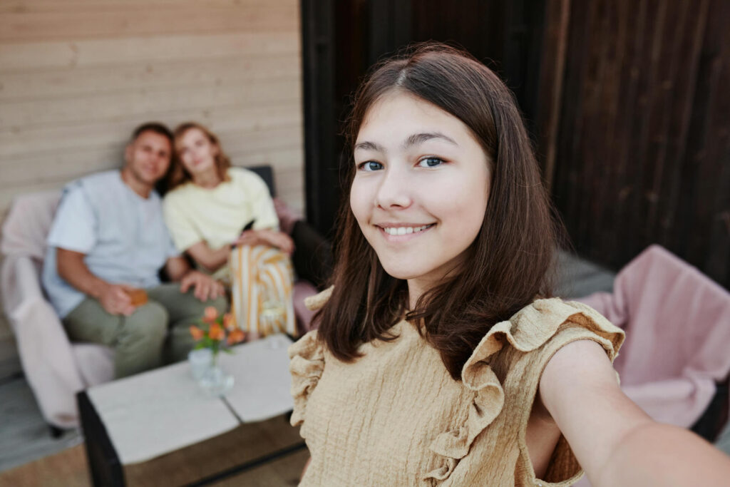 A girl with her parents at the background