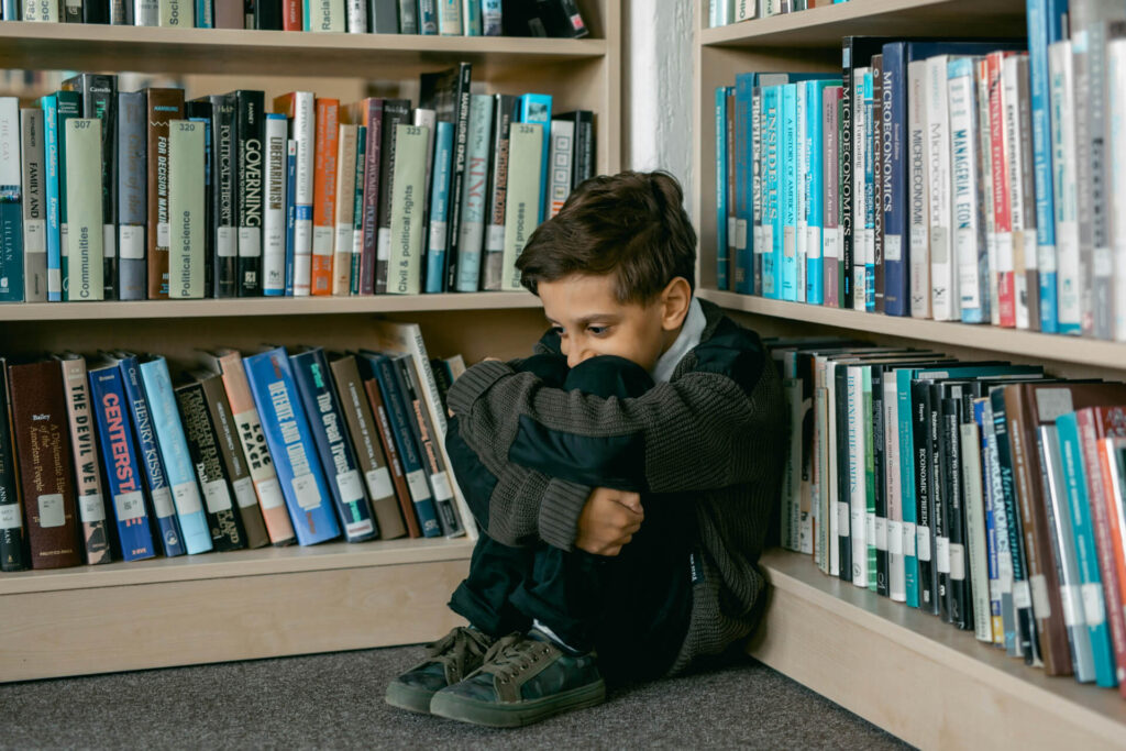 A kid sitting on a corner